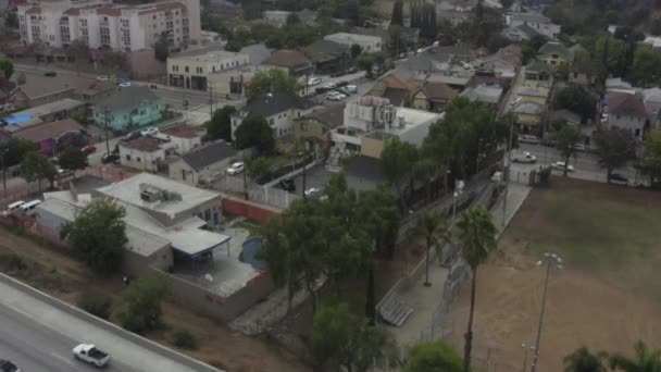 AERIAL: Blick auf den Highway, dann nach Downtown Los Angeles, Kalifornien, mit Palmen, bewölkt — Stockvideo