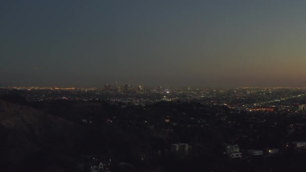 AERIAL: Sobre Hollywood Hills por la noche con vista al centro de Los Ángeles , — Vídeo de stock