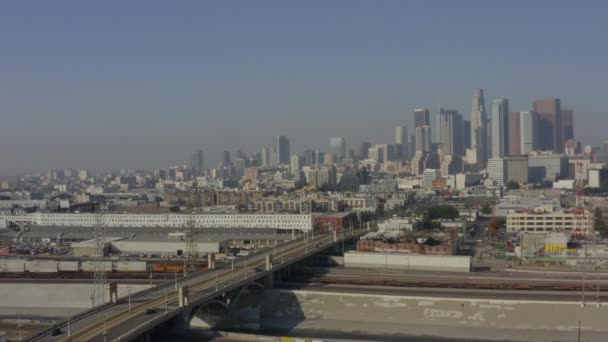 AERIAL: Río LA, vías de tren con el centro de Los Ángeles en el fondo, la luz del sol — Vídeos de Stock