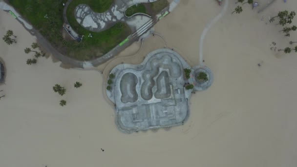 AERIAL: Birds View 180 degree turn over Venice Beach Skate Park, Los Angeles, Califórnia Nublado — Vídeo de Stock