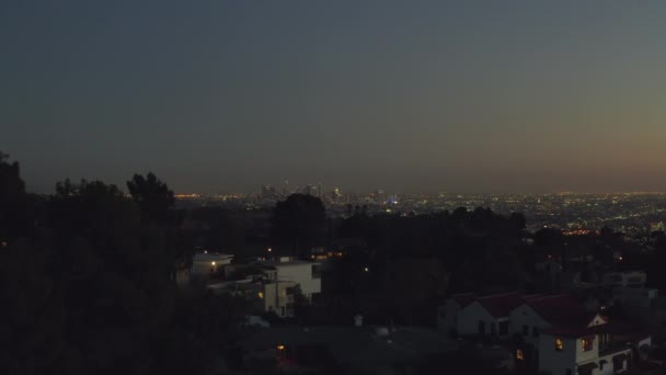 AERIAL: Sobre Hollywood Hills por la noche con vista al centro de Los Ángeles , — Vídeos de Stock