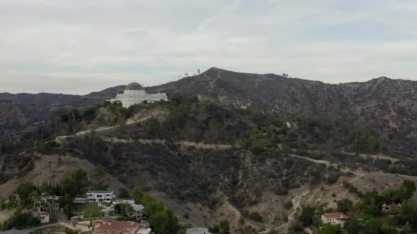 AERIAL: Obserwatorium Griffith z przelotem nad wzgórzami Hollywood w dzień, Los Angeles, Kalifornia, Cloudy — Wideo stockowe