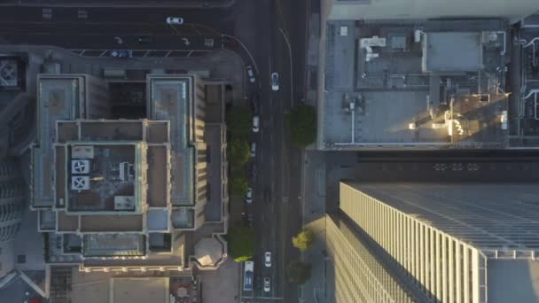 AERIAL: Slow Birds eye Volo sopra Downtown Los Angeles California nella bellissima Sunrise Light con vista sui tetti dei grattacieli e sul traffico automobilistico che passa — Video Stock