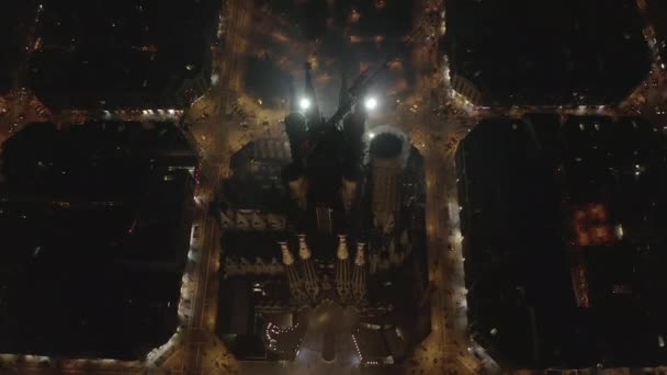 AERIAL: Cerrar plano aéreo de la Sagrada Familia por la noche con hermosos semáforos de la ciudad — Vídeos de Stock