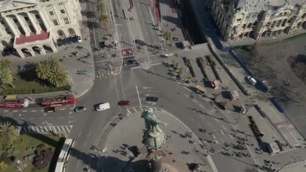 AERIAL: Primer plano del Monumento a Colón en Barcelona, España en el hermoso día soleado con tráfico de coches ocupado en la rotonda — Vídeos de Stock