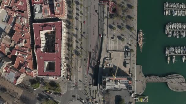 AERIAL: Overhead Shot a lo largo de Barcelona, España Bahía con barcos en el agua en el día soleado — Vídeos de Stock