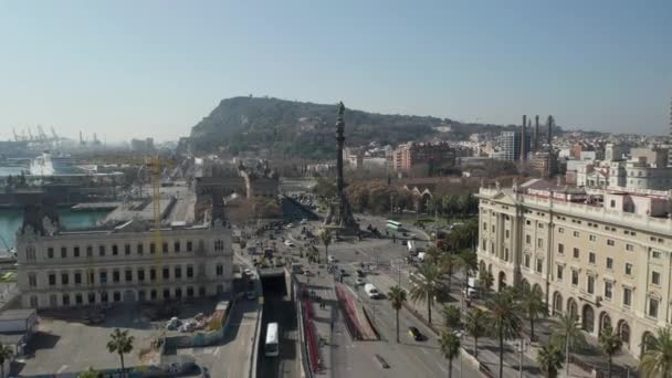 AERIAL: Vuelo lento hacia el Monumento a Colón en Barcelona, España con palmeras en un hermoso día soleado — Vídeos de Stock