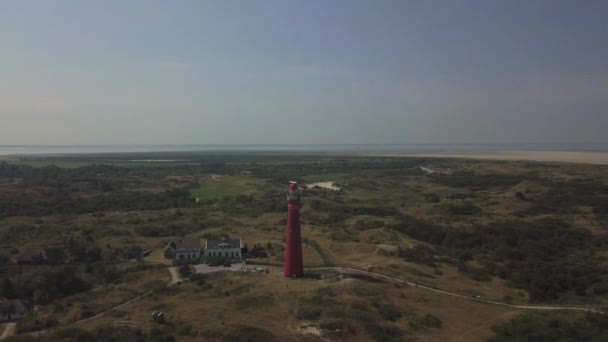 AERIAL：美丽岛屿上的红色灯塔，夏季有海滩，荷兰 — 图库视频影像