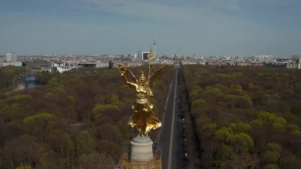 AERIAL: Close Up Circling around Berlin Victory Column Golden Statue Victoria in Beautiful Sunlight and Berlin, Germany City Scape Skyline in Background — Stock Video