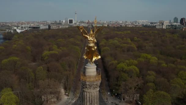 AERIAL: Close Up Dolly of Berlin Victory Column Golden Statue Victoria in het prachtige zonlicht en Berlijn, Duitsland City Scape Skyline op de achtergrond — Stockvideo