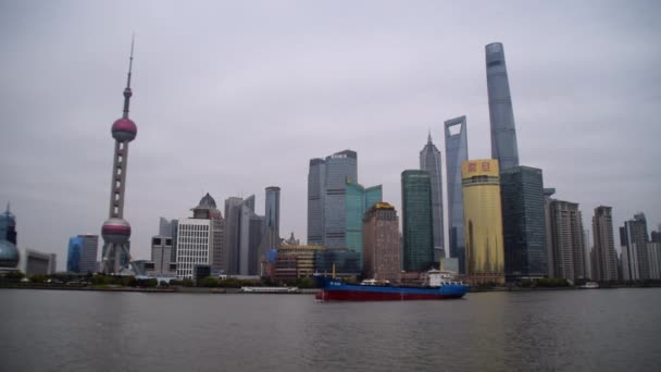 Lihat di Shanghai Skyline di atas Sungai Bund dengan perahu besar mengemudi di atas sungai pada hari berawan — Stok Video