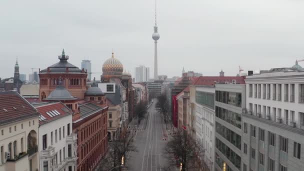 AERIAL: Vuelo lento a través de Empty Central Berlin Neighbourhood Street con catedrales y vista de Alexanderplatz TV Tower durante el virus Corona COVID19 en el día nublado nublado — Vídeos de Stock