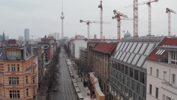 AERIAL: Langsamflug durch die Leere Berliner Kiezstraße mit Kathedralen und Blick auf den Fernsehturm Alexanderplatz während Corona Virus COVID19 am bewölkten Tag — Stockvideo