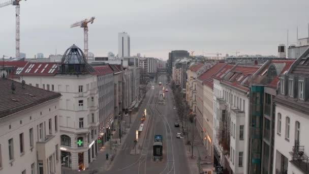 АЭРИАЛ: медленный полет над пустой центральной улицей Берлина, где почти нет людей и нет машин, во время короны COVID19 в пасмурный день — стоковое видео