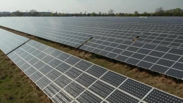 AERIAL: Primer plano Vuelo sobre paneles solares que producen energía verde y respetuosa con el medio ambiente del sol. Parque de plantas solares produciendo energía renovable para un desarrollo sostenible — Vídeos de Stock