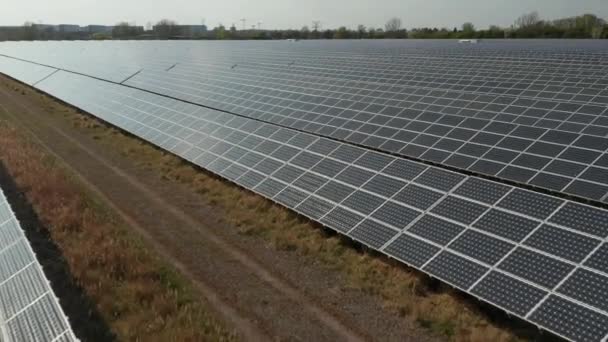 AERIAL: Primer plano Vuelo sobre paneles solares que producen energía verde y respetuosa con el medio ambiente del sol. Parque de plantas solares produciendo energía renovable para un desarrollo sostenible — Vídeos de Stock