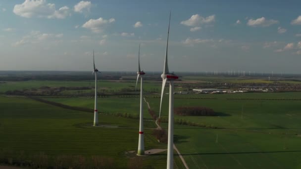 AERIAL: Närbild skott av vindturbin, Mill roterande av kraften i vinden generera förnybar energi på ett grönt ekologiskt sätt för planeten över vackra gröna jordbruksfältet — Stockvideo