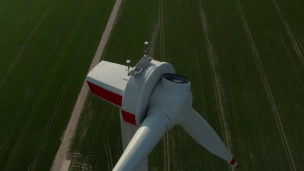 AÉRIEN : Gros plan Des éoliennes circulantes en construction sont construites sur un riche champ agricole vert — Video