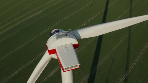 AERIAL: Close-up van windturbine in aanbouw wordt gebouwd op een rijk groen landbouwveld — Stockvideo