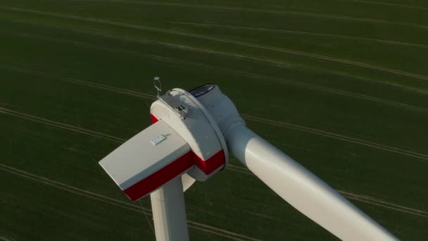 AERIAL: Im Bau befindliche Windenergieanlage aus nächster Nähe auf sattgrünem Acker — Stockvideo