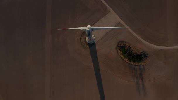 AERIAL: Κοντινό πλάνο Overhead του ανέμου Turbine, Μύλος περιστρέφεται από τη δύναμη του ανέμου Παραγωγή Ανανεώσιμων Πηγών Ενέργειας σε ένα πράσινο οικολογικό τρόπο για τον πλανήτη πάνω από όμορφο τομέα της πράσινης γεωργίας — Αρχείο Βίντεο