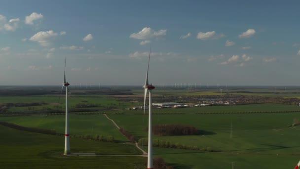 AERIAL: Vista de la granja de molinos de viento para la producción de energía en el hermoso día del cielo azul con nubes. Turbinas eólicas generadoras de energía renovable limpia para el desarrollo sostenible — Vídeo de stock