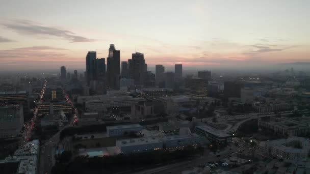 AERIAL: Vista cinemática del centro de Los Ángeles justo después del atardecer con las luces de Skyline City y el tráfico de coches — Vídeos de Stock