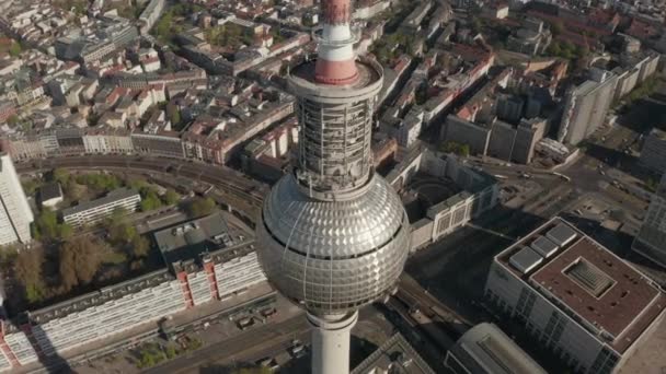 AERIAL: Wide view of the top of Alexander Platz TV Tower with empty Berlin, Germany Street in background on hot summer day during COVID-19 Corona Virus Panprevalence — 图库视频影像