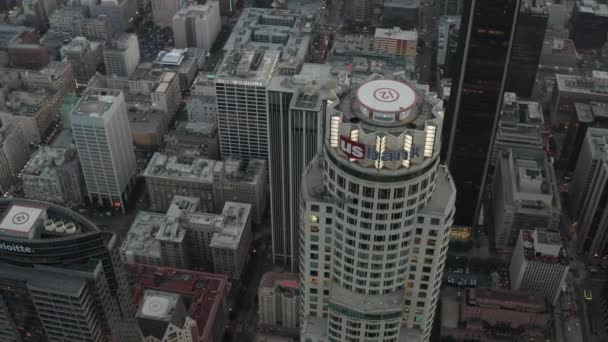 AERIAL: Hermosa vista de aves aéreas en círculo del famoso rascacielos en el centro de Los Ángeles, California bajo la luz del atardecer — Vídeos de Stock
