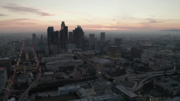 AERIAL: lélegzetelállító kilátás a felhőkarcolók Los Angeles belvárosában, Kaliforniában a gyönyörű naplementében — Stock videók