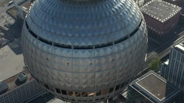 AERIAL: Super Close Up Blick auf die Spitze des Fernsehturms am Alexander Platz mit Berliner Straßen im Hintergrund an heißen Sommertagen — Stockvideo