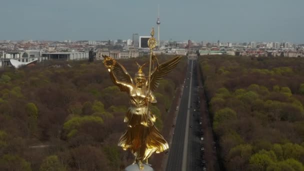 AERIAL: Close Up Circling around Berlin Victory Column Golden Statue Victoria in Beautiful Sunlight and Berlin, Germany City Scape Skyline in Background — Αρχείο Βίντεο