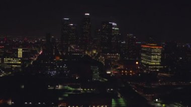Şehir merkezindeki gökdelenlere, Skyline Los Angeles, California 'ya gece yarısı şehir ışıklarıyla uçuyorum., 