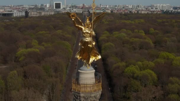 AERIAL: Close Up Dolly of Berlin Victory Column Golden Statue Victoria in Beautiful Sunlight and Berlin, Germany City Scape Skyline in Background — 비디오