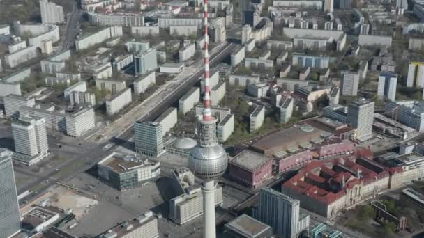 AERIAL: Voo aéreo aéreo de tirar o fôlego sobre a Torre de TV Alexander Platz em Berlim vazia, Alemanha, quase sem pessoas ou carros no belo dia ensolarado — Vídeo de Stock
