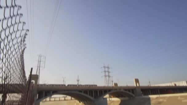 Panela para baixo no Rio Los Angeles com Tram Train ponte de travessia no céu azul Dia de verão em SLOW MOTION — Vídeo de Stock