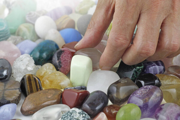 Close up of Crystal healer choosing a tumbled healing stone