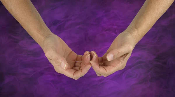 The Humble Healer -  female hands with the back of the fingers touching in a gentle gesture of hope isolated on a purple energy formation background