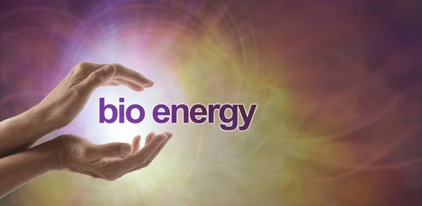 Bio Energy - yet another name for healing - female cupped hands with the words BIO ENERGY floating between against a white pink and orange vortex energy formation background