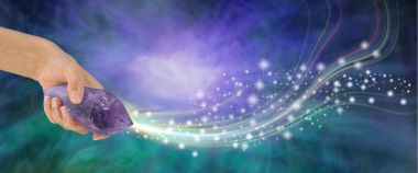 Massive Amethyst with beautiful energy - female hand holding large terminated amethyst quartz wand  shooting out sparkles across a purple and jade energy background with copy space clipart