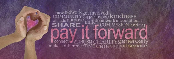 PAY IT FORWARD with love word cloud - campaign banner with female hands making a heart shape on left with a PAY IT FORWARD word cloud beside on a rustic parchment background