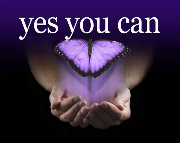 Your Mentor says YES YOU CAN - Male cupped hands emerging from black background with a large purple coloured  butterfly rising upwards towards the words YES YOU CAN
