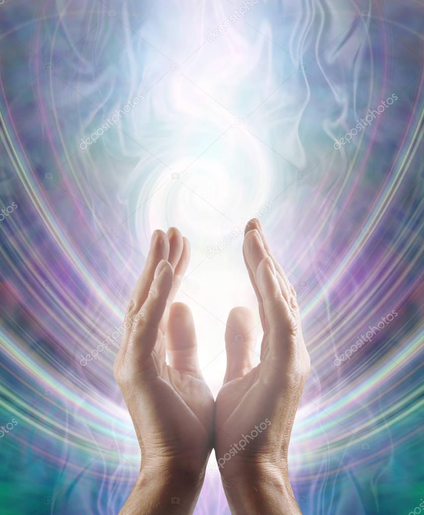 Sensing Spiralling Healing Energy - male  hands reaching up and sensing an ethereal spiralling white light flowing energy form with copy space 