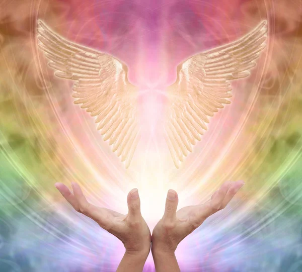 守護天使からの助けと指導を求めて 女性の手は エーテルの虹色のエネルギーの背景に輝く輝く天使の翼のペアに到達します ストックフォト