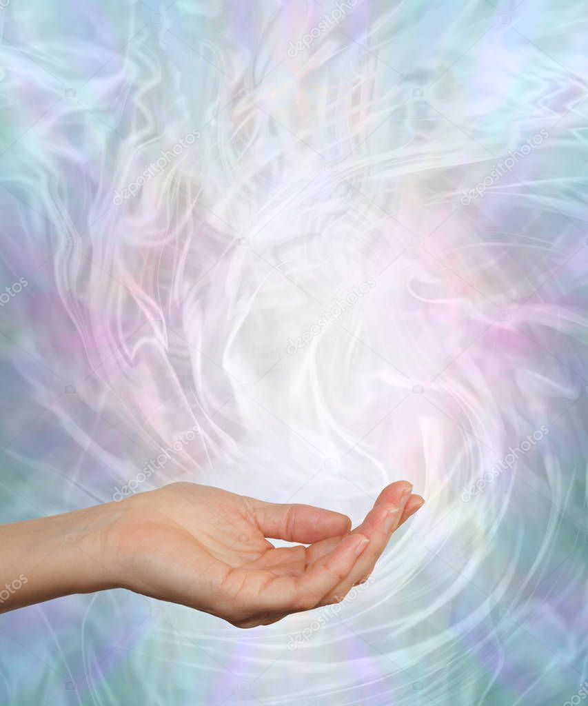 Gently Swirling Cool Healing Energy - Female open palm surrounded by a pale blue and pink energy field with copy space