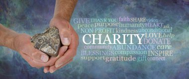 Heart felt Charity Word Cloud - Erkek elleri taşralı ahşap bir kalbi bir Charity sözcüğü bulutunun yanında tutarken erkeksi grunge rustik taş efekti benzin rengi mavi arka plan                               