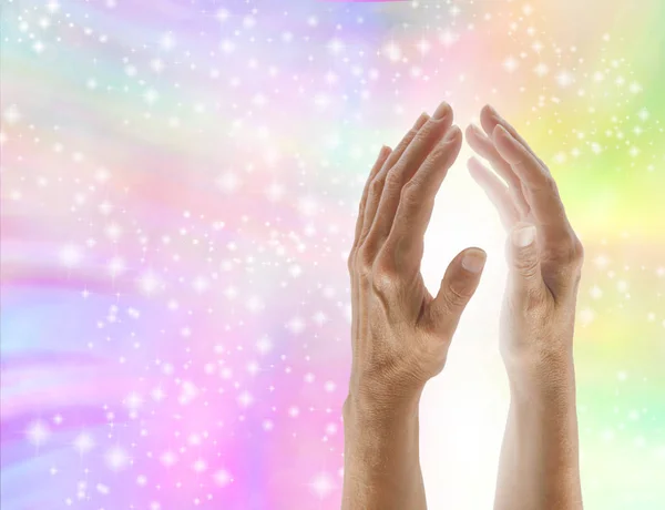 Bringing in healing light - parallel healing hands with bright white light between against a soft pastel multi coloured sparkling background with copy space on left side — Stock Image Bringing Healing Light Parallel Healing Hands Bright White Light Soft Stock Image