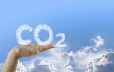 Karbondioksit emisyonları Ellerinizde - açık kadın eli bulutlu CO2 'nin mavi bir gökyüzü zemininde yüzdüğünü ve altında kabarık bulutlar olduğunu söylüyor ve uzayı kopyalayın