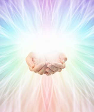 Using colour healing full spectrum energy background - female cupped hands with rainbow coloured light flowing out in all directions from central white orb light and copy space all around clipart