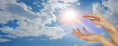 Bulutların arasından yükselen ilahi güneş ışığı. Geniş gökyüzü sancağı. Büyük kabarık bulutlar ve parlak bir güneş.